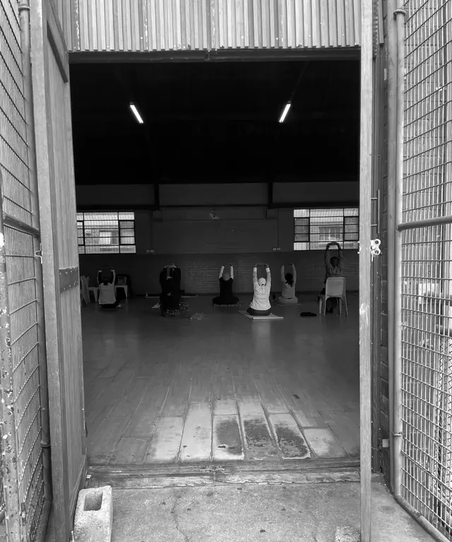 Looking through the open door of a community hall in Soweto, where a group is sitting together.